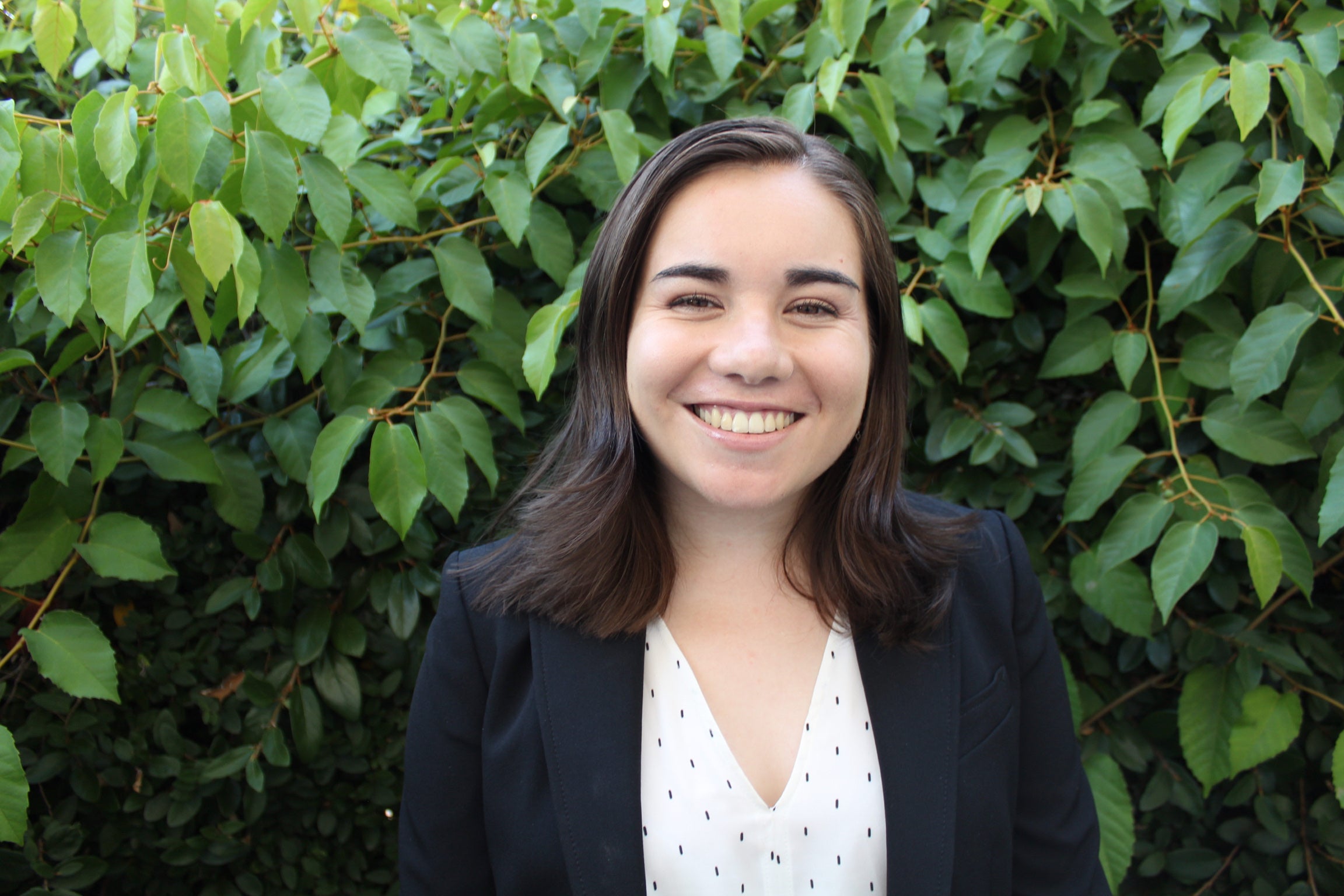 Madeline Gibbons Shapiro smiles against a leafy backdrop