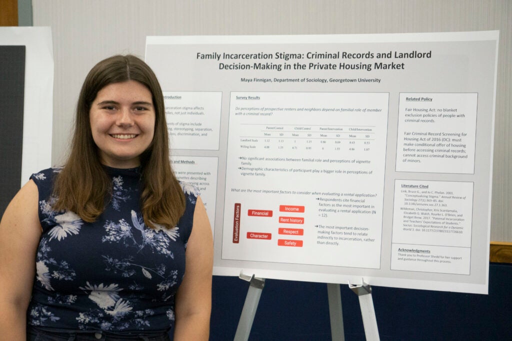 Senior Maya Finnegan poses in front of their presentation