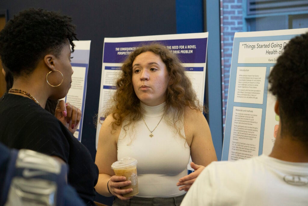 Senior Karis Danner-McDonald discusses their presentation with Professor Carla Shedd