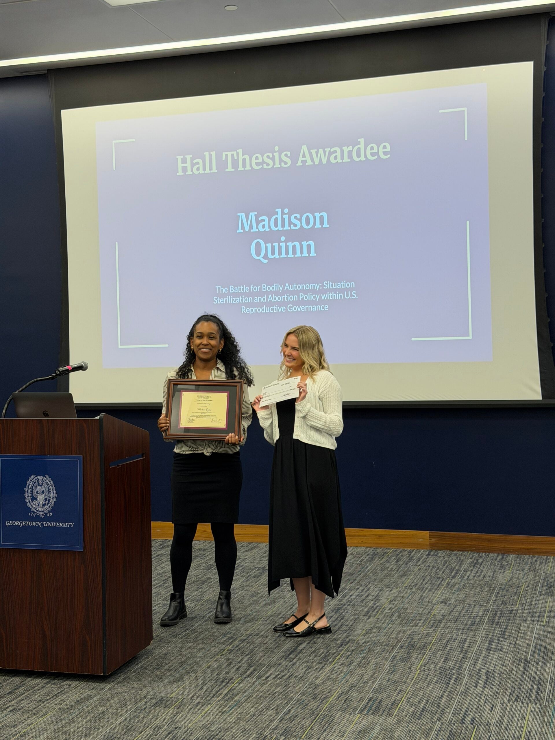 Madison Quinn accepting Hall award for her sociology thesis. Presented by Professor Alyssa Newman.